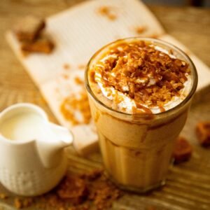 A refreshing iced coffee topped with caramel and cream serves as a delicious treat for coffee lovers.