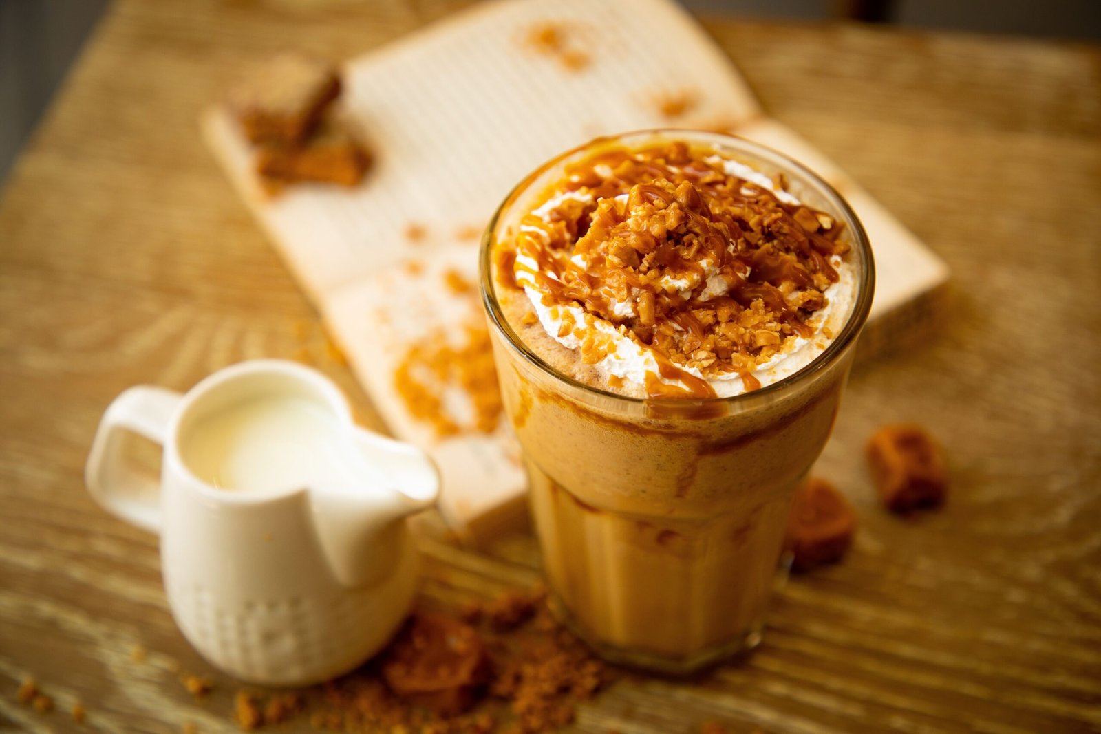 A refreshing iced coffee topped with caramel and cream serves as a delicious treat for coffee lovers.